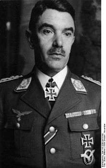 A man wearing a military uniform with an Iron Cross displayed at the front of his uniform collar.