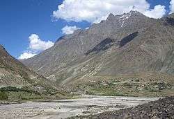 Village on a river at the foot of a mountain range