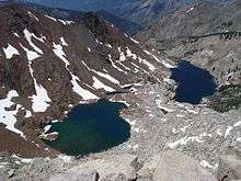 Two dark blue lakes set in a gray granite basin