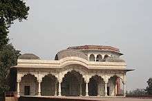 Low, white building with ornate pillars and arches