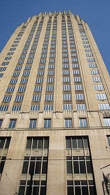 A photograph of an early-1900s skyscraper seen from the ground level looking up