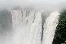 Wide photo of large waterfall in mist