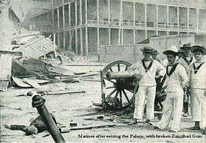 British sailors pose with a captured cannon outside the sultan's palace