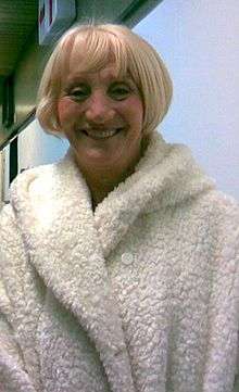 A smiling woman in a fluffy white coat