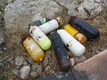  A pile of rejected and somewhat rusty scuba cylinders lying in a yard