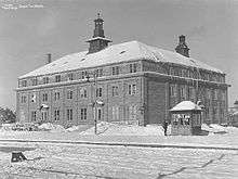 Square, three-story hotel in winter