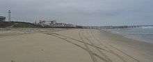 U.S.-Mexico Border at the Pacific Ocean in Imperial Beach, California. (Tire tracks from Border Patrol Jeeps are visible on the beach.)